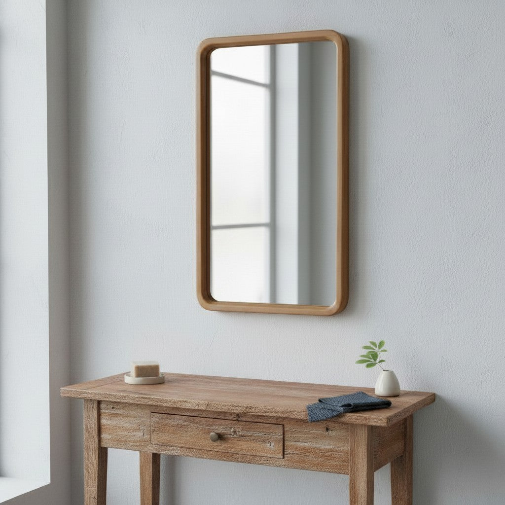 CRUSOË Lyndi rectangular mirror with rounded teak wood frame, hanging above a wooden console table.